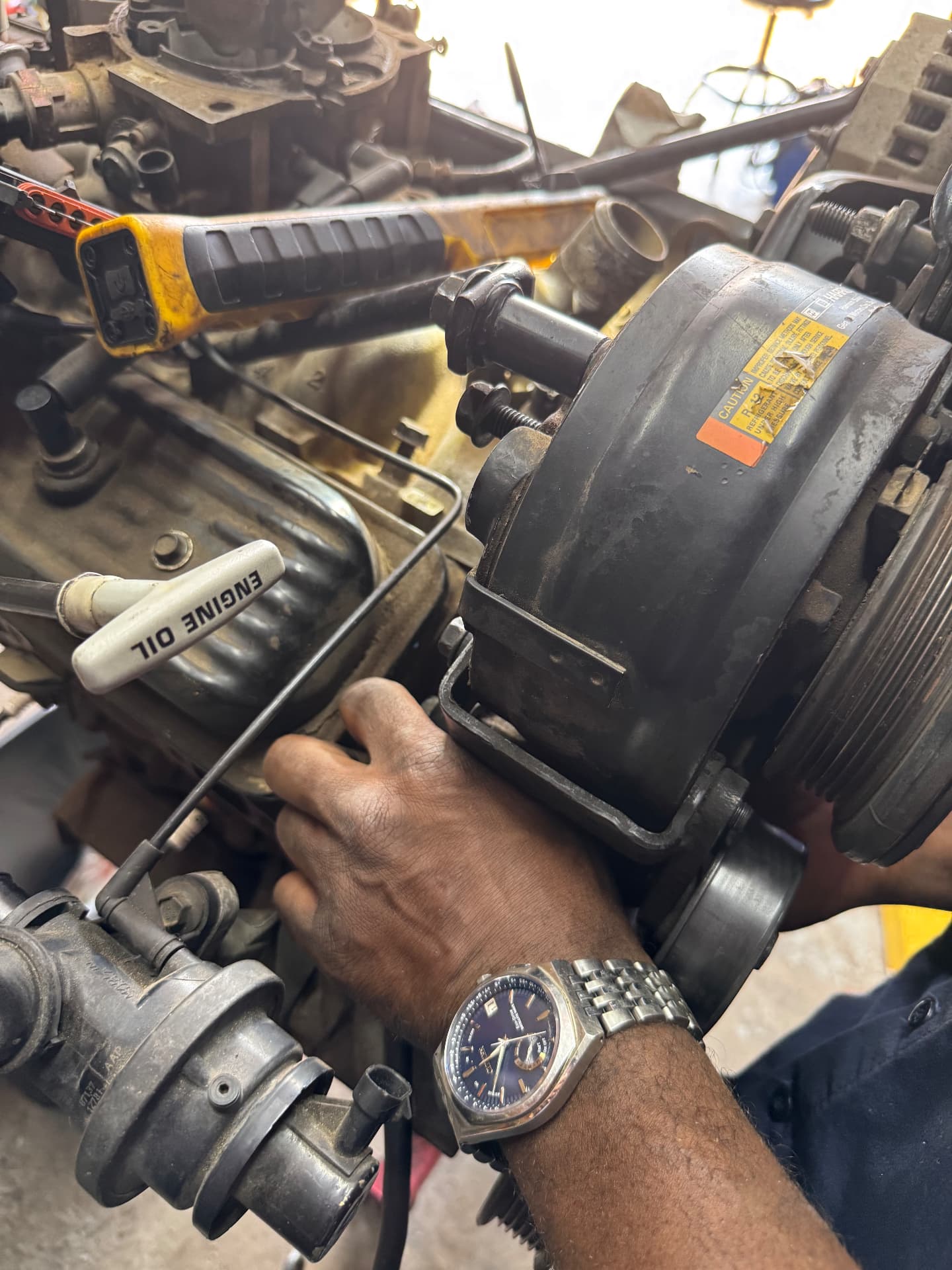 Hands of a BLB Auto mechanic working on an engine